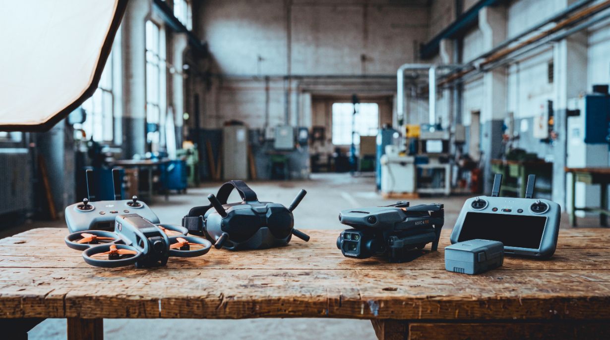 FPV-Drohne mit Videobrille und klassische Kameradrohne mit Fernsteuerung in einer Industriehalle