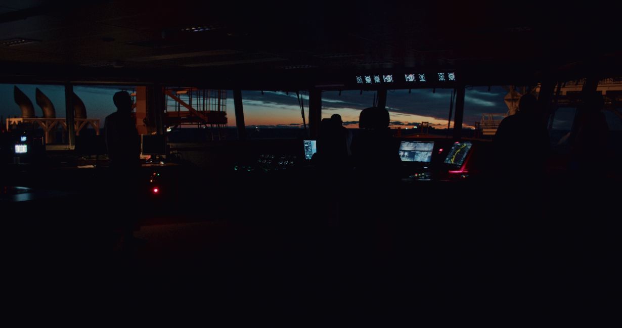 Dunkle Schiffsbrücke mit beleuchteten Navigationsinstrumenten während des Offshore-Einsatzes